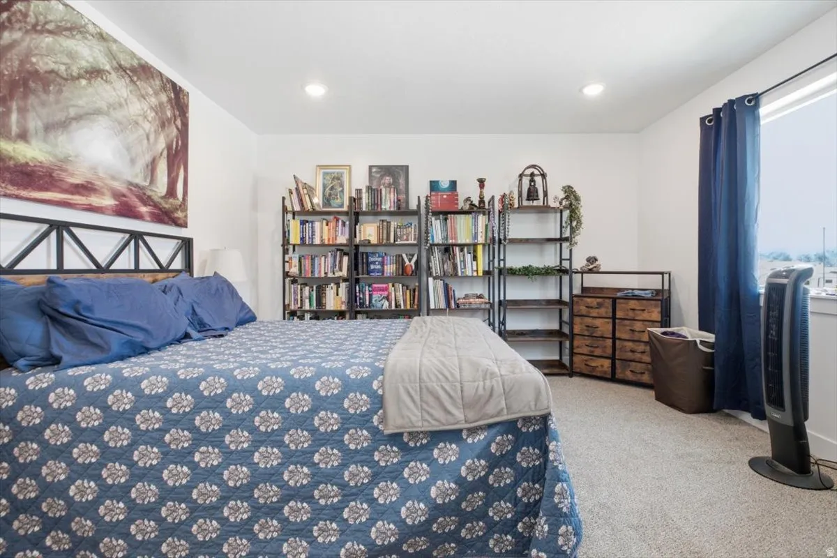 Recessed lighting, light-colored carpeting, and a window with a dark curtain