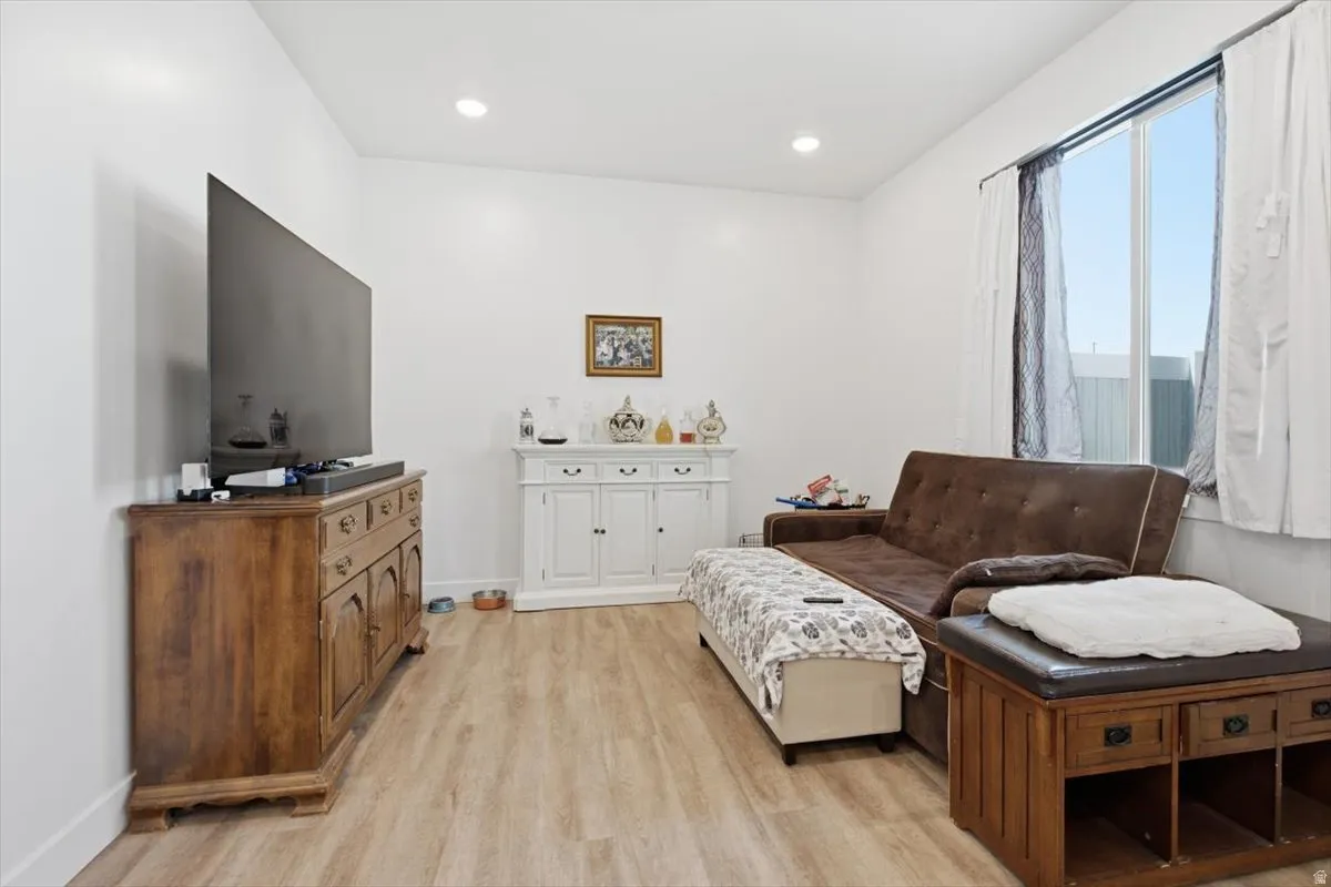 Recessed lighting, wood-finish flooring, and a window with natural light
