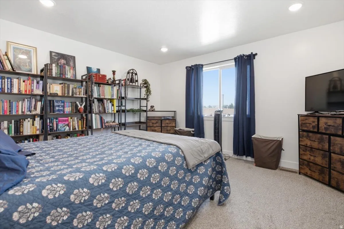 Recessed ceiling lighting, white walls, and light-colored carpet flooring