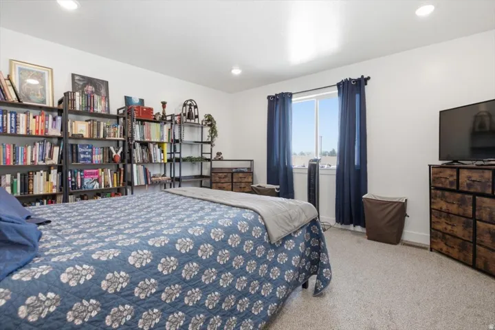 Recessed ceiling lighting, white walls, and light-colored carpet flooring