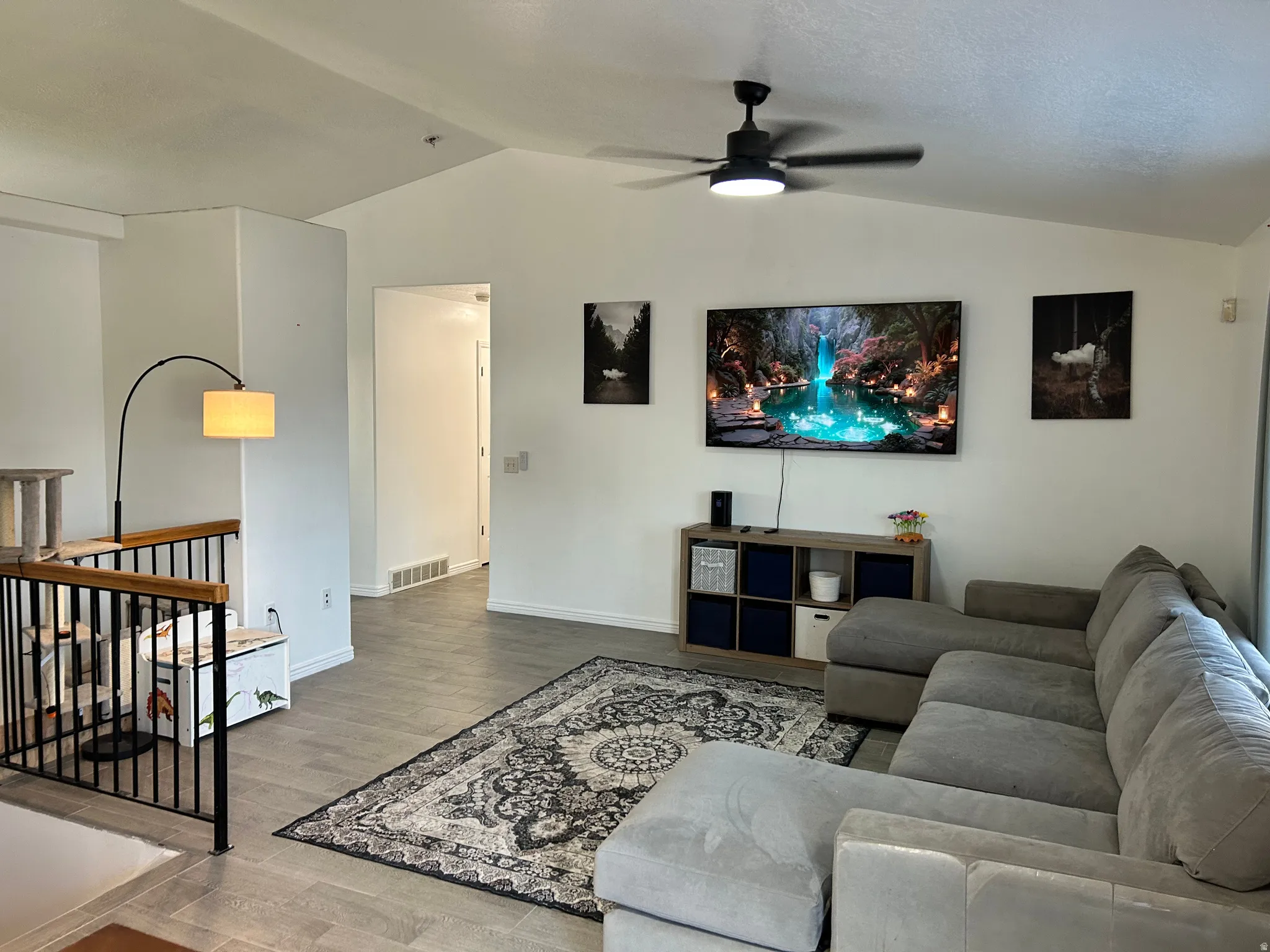 Vaulted ceilings, a contemporary ceiling fan with integrated lighting, and tile flooring create an open atmosphere