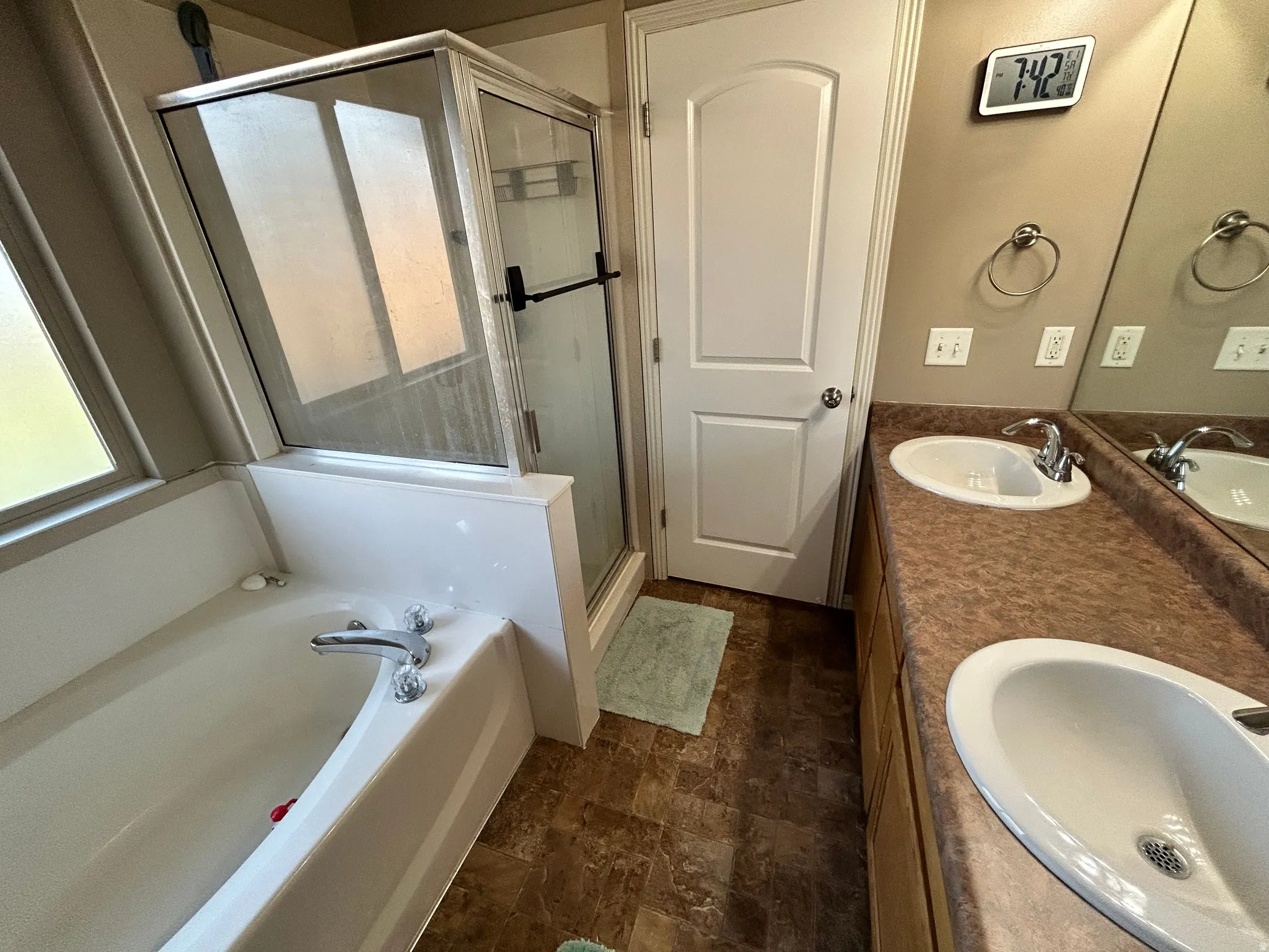 Dual vanity with integrated sinks, full-width mirror, and brown-toned countertop