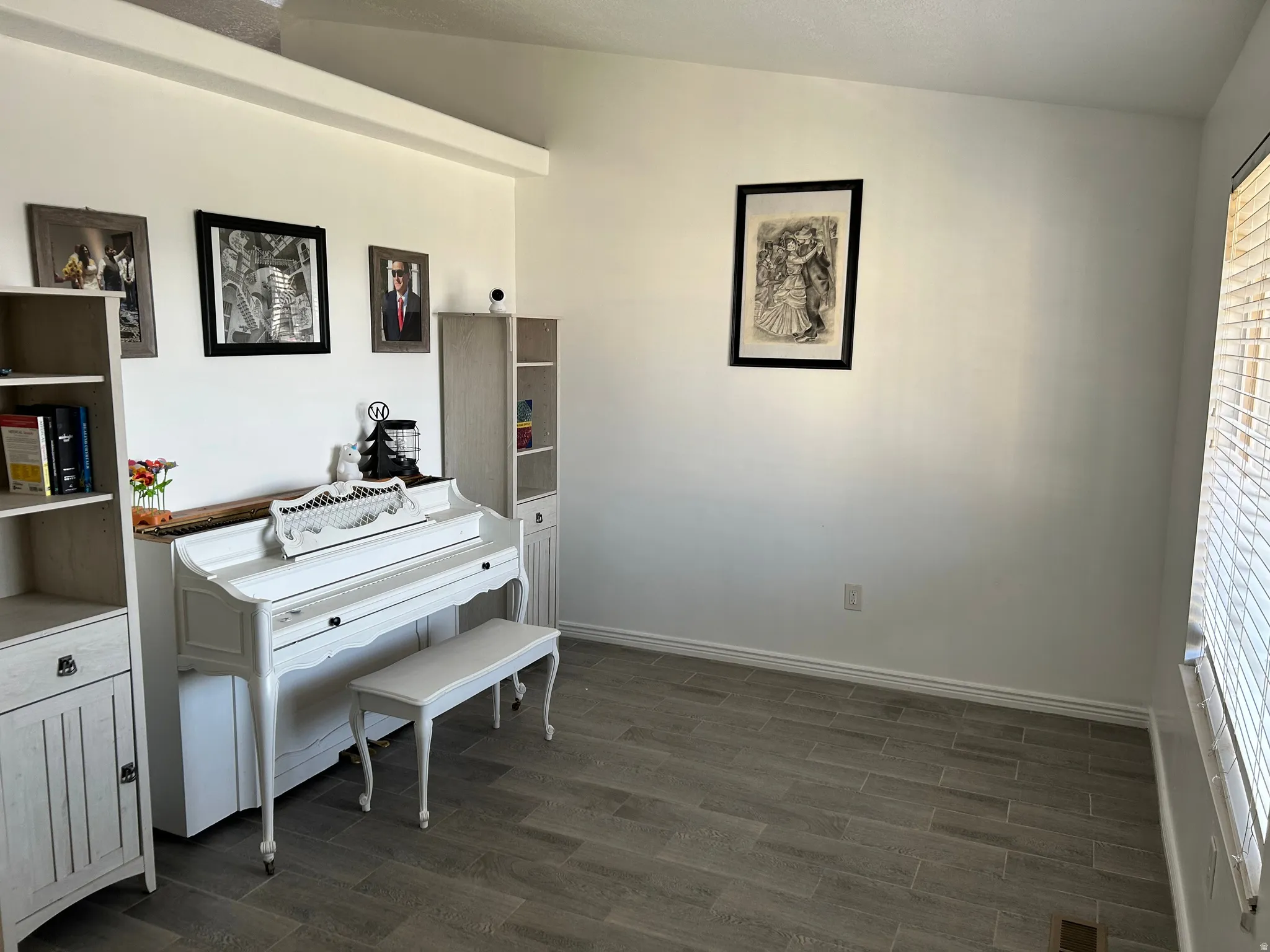 Room featuring wood-finish tile flooring and an overhead ceiling beam