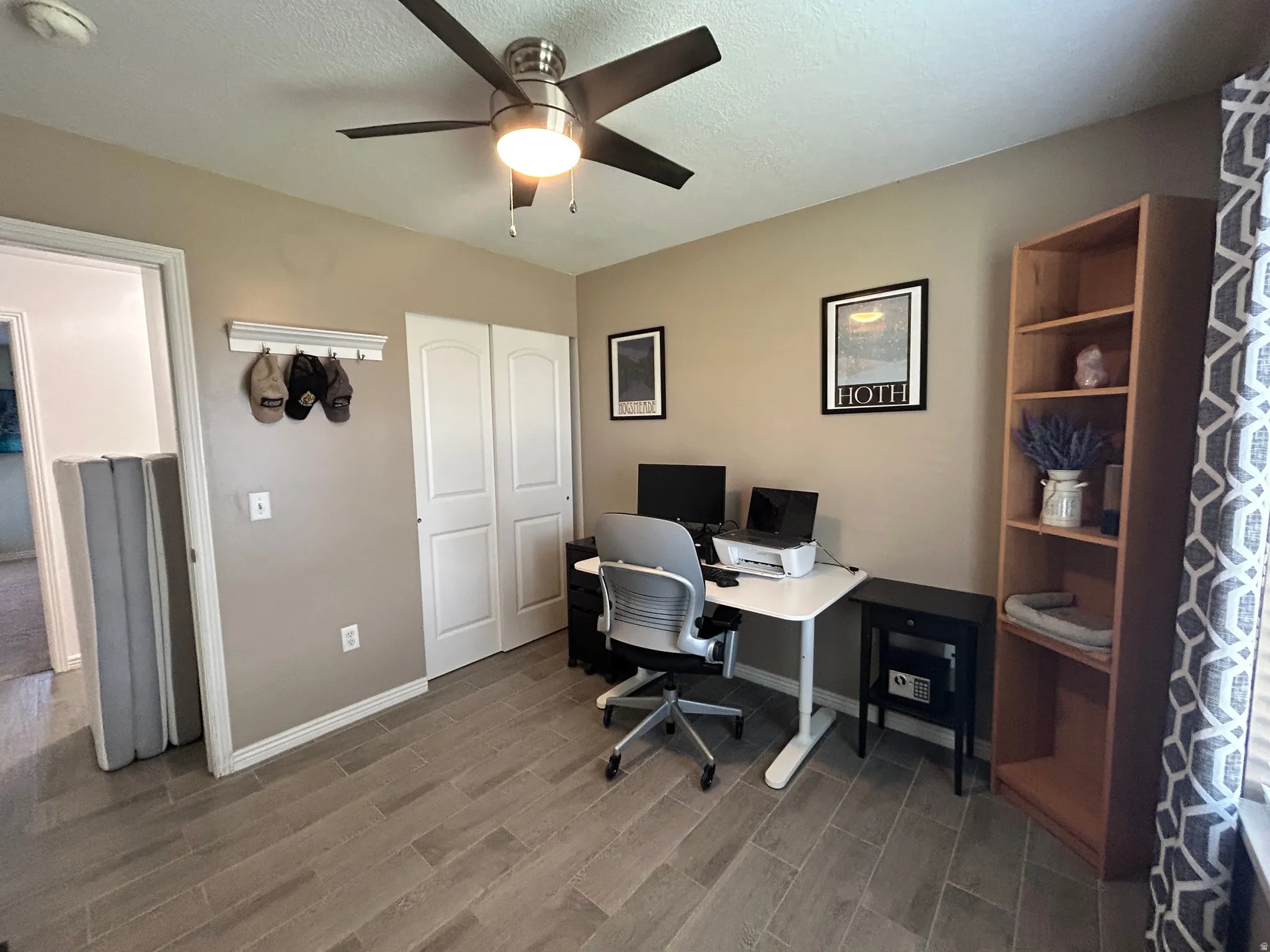 Ceiling fan with integrated lighting, wood-finish flooring, built-in shelving unit, and bifold closet doors