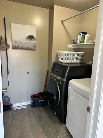 Wood-finish tile flooring, wall-mounted shelving, and a metal hanging rod