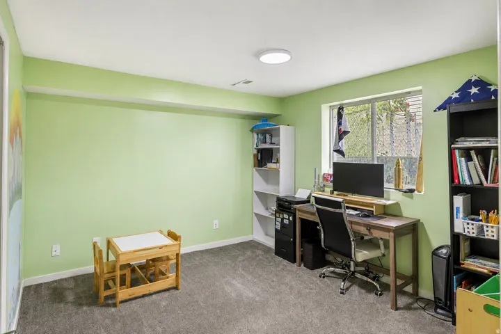Carpeted flooring, recessed ceiling light, and a single window with a white frame