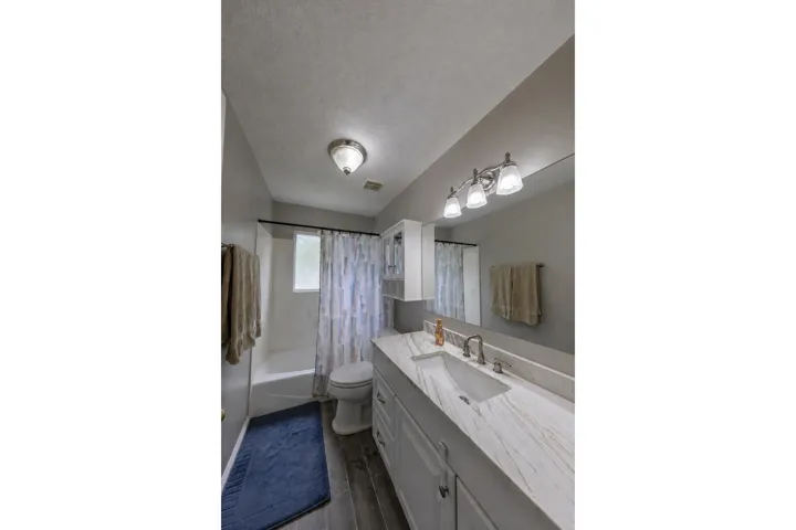 Spacious vanity with a light-toned countertop, undermount sink, and brushed nickel fixtures