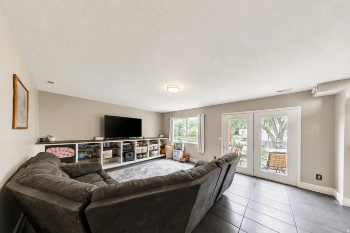 Recessed ceiling lighting, built-in shelving, two windows, and French doors leading to exterior