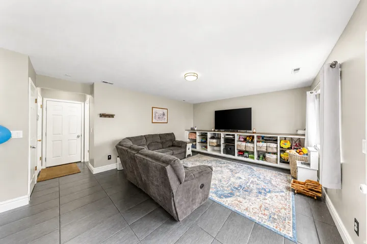 Neutral wall tones, gray tile flooring, built-in shelving, and recessed lighting