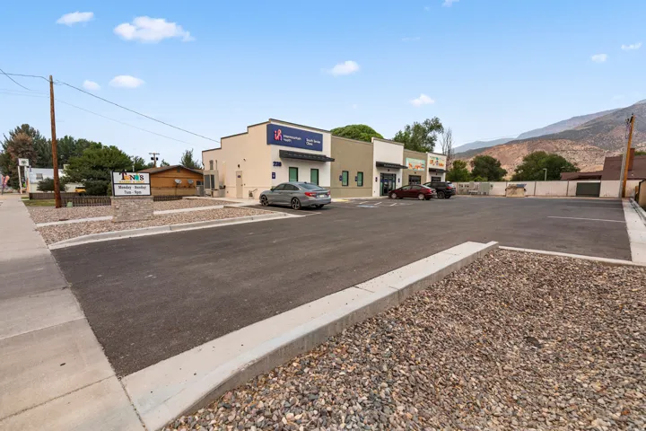 Paved parking area featuring concrete curbing and decorative gravel landscaping