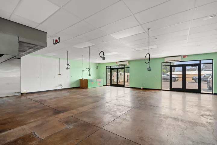 Spacious interior with concrete flooring and drop ceiling