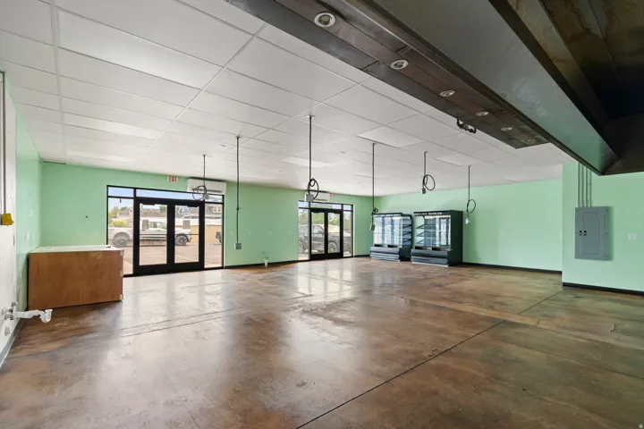Open floor plan featuring concrete flooring, suspended ceiling panels, and recessed lighting