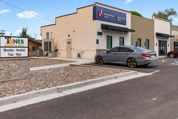 Commercial building with stucco exterior, multiple entry points, and a paved parking area