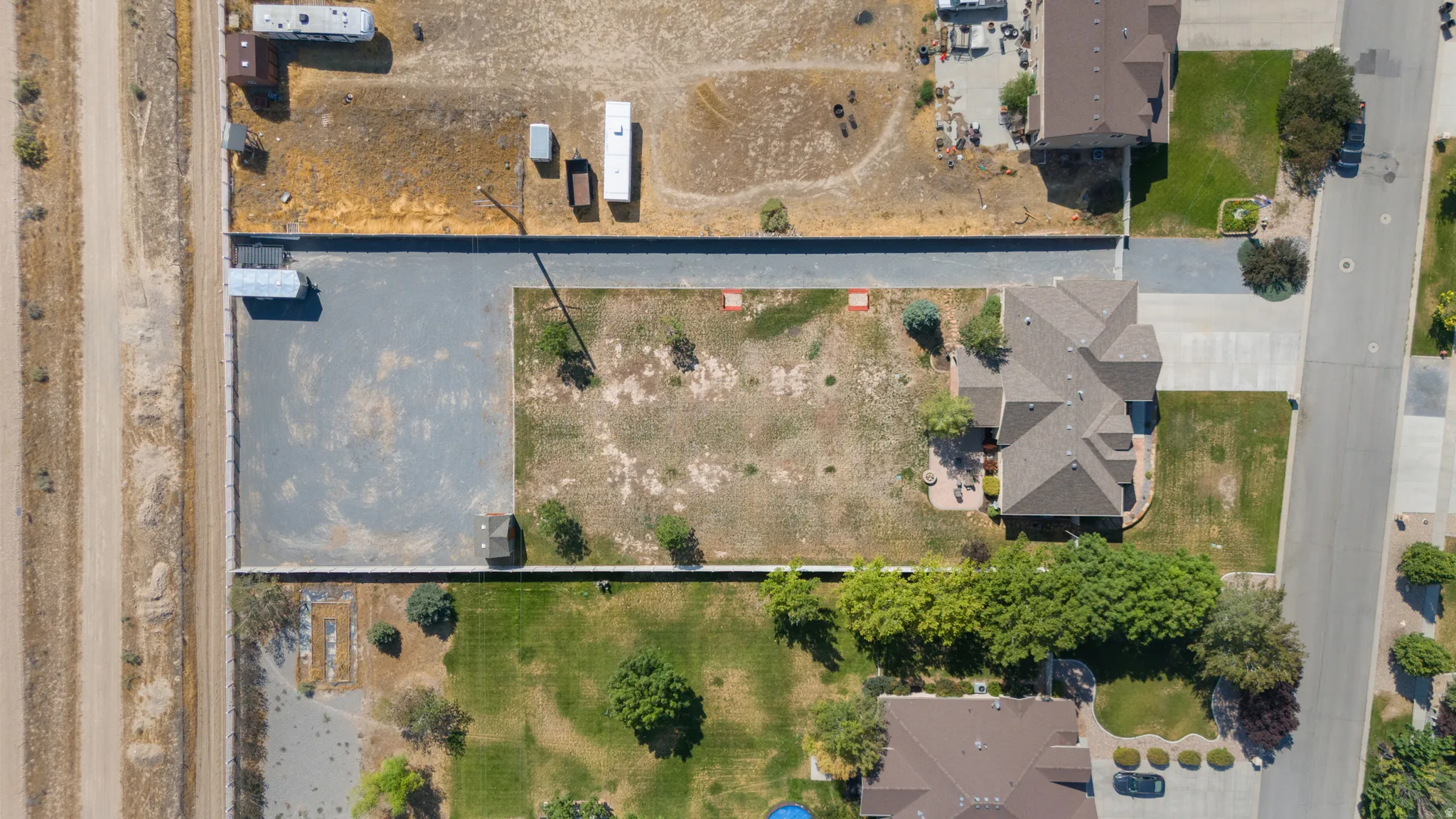 Extensive property featuring a large gravel area, a multi-gabled roofline, and a paved driveway