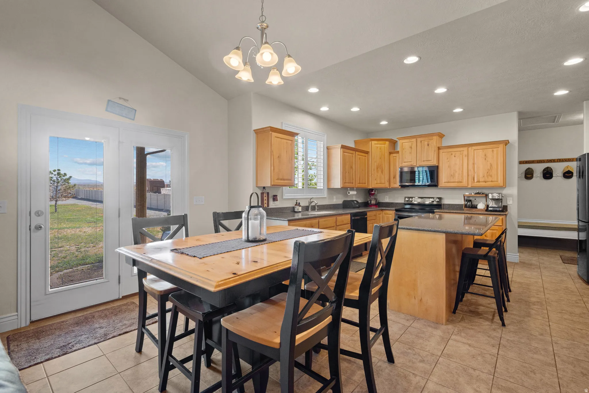 Kitchen featuring wood-finish cabinetry, a central island with a breakfast bar, recessed lighting, and tile flooring