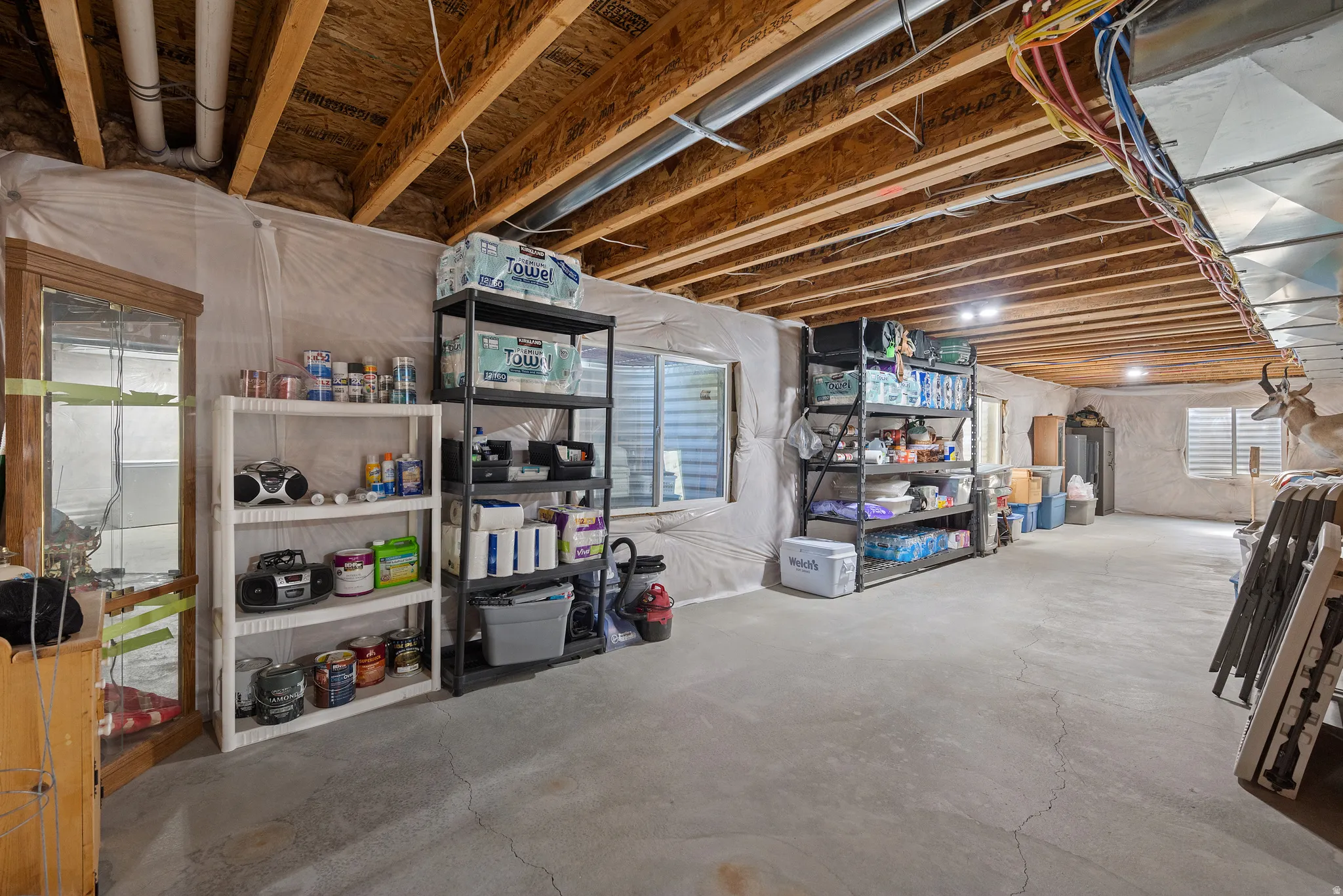 Unfinished basement space with exposed wood joists and concrete flooring