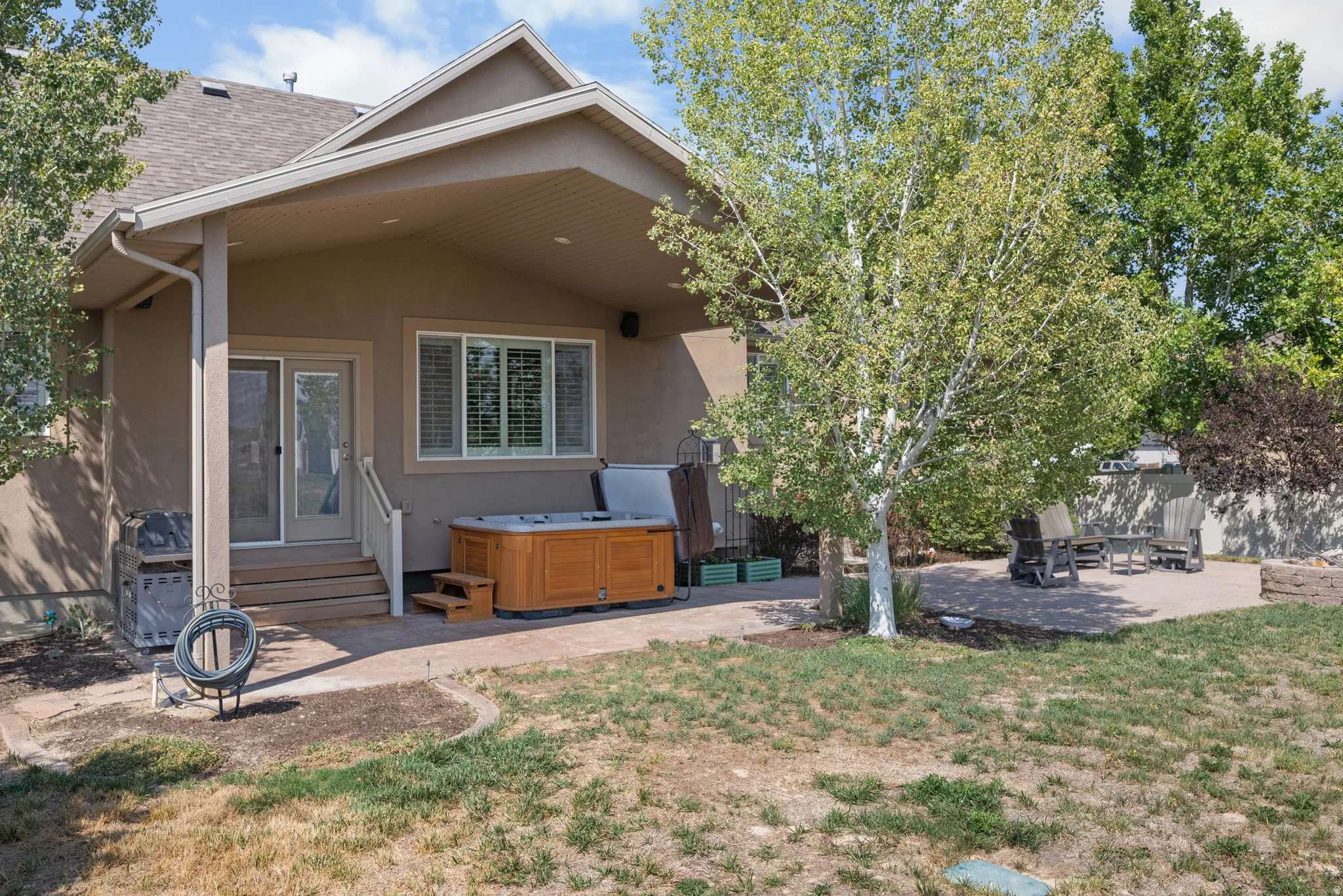 Covered patio with recessed lighting, stucco exterior, and a built-in spa