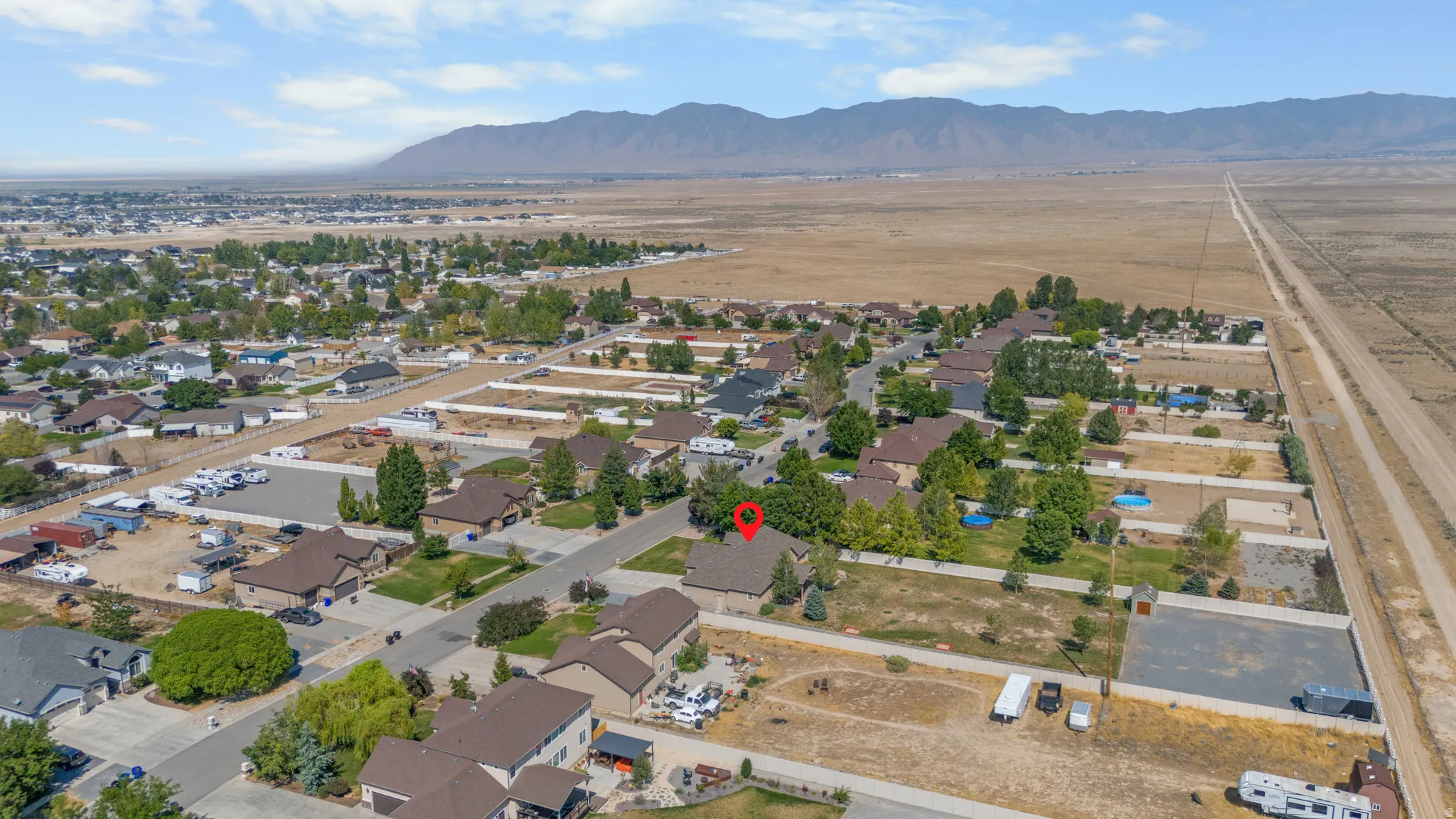 Residential neighborhood with established homes and mature trees, featuring distant mountain ranges