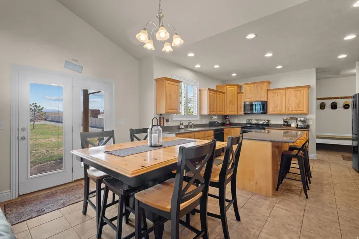 Kitchen featuring wood-finish cabinetry, a central island with a breakfast bar, recessed lighting, and tile flooring
