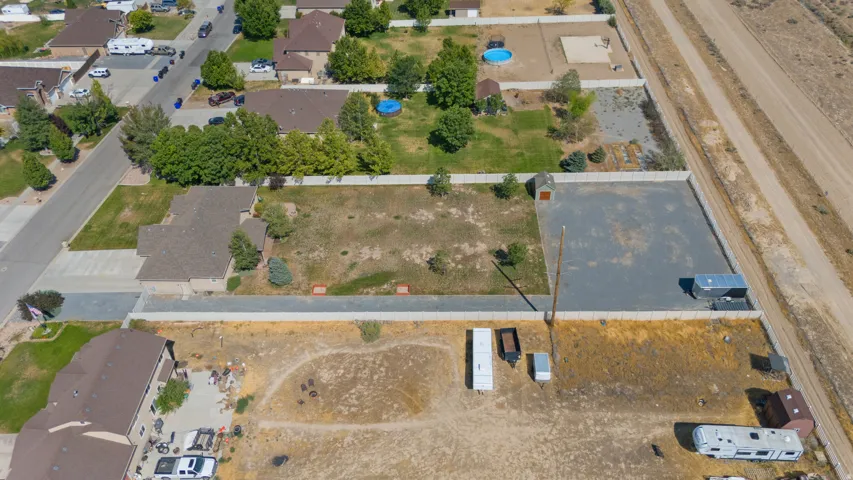 Expansive parcel with a large gravel lot, enclosed by a perimeter fence