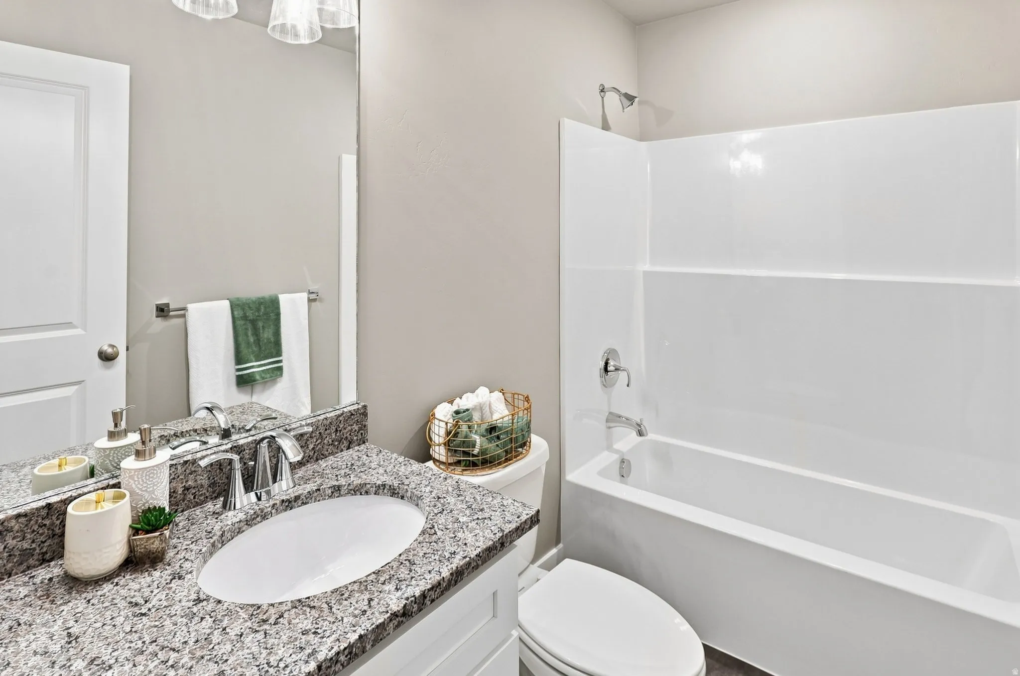 Bathroom featuring a white vanity with a granite countertop, undermount sink, and chrome fixtures