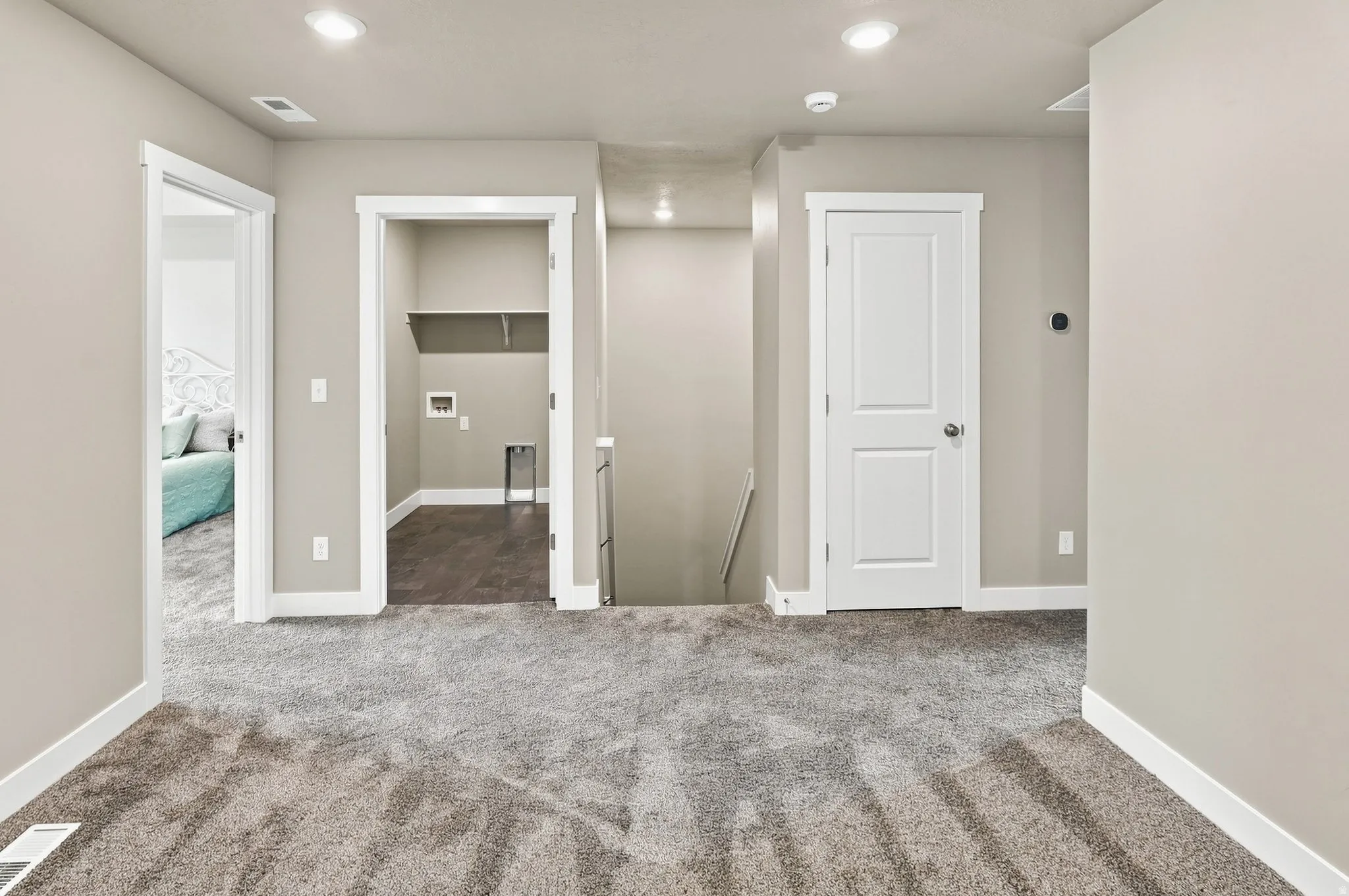 Open landing area featuring plush carpet, recessed lighting, and crisp white trim