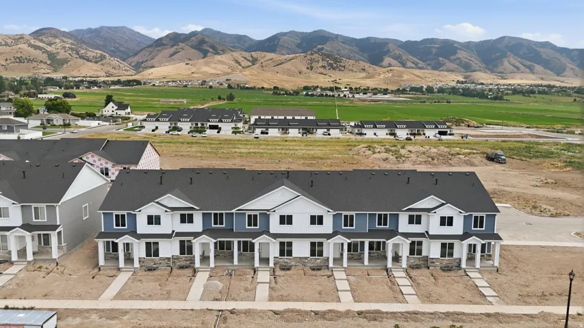 Contemporary townhomes featuring stone and siding exteriors, dark shingle roofing, and white trim