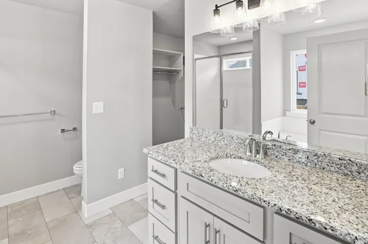 Double vanity with a granite countertop, undermount sinks, and chrome faucets