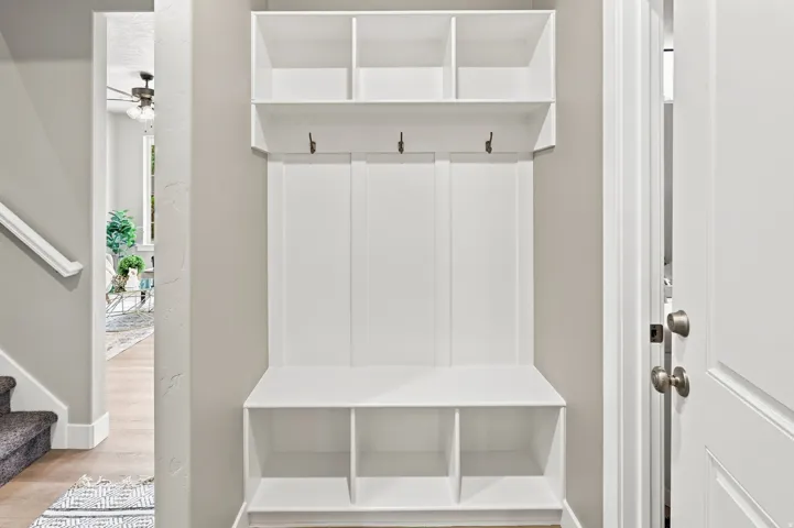 Built-in storage bench with three open compartments and upper shelving