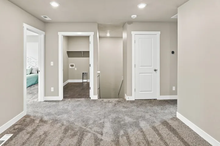 Open landing area featuring plush carpet, recessed lighting, and crisp white trim