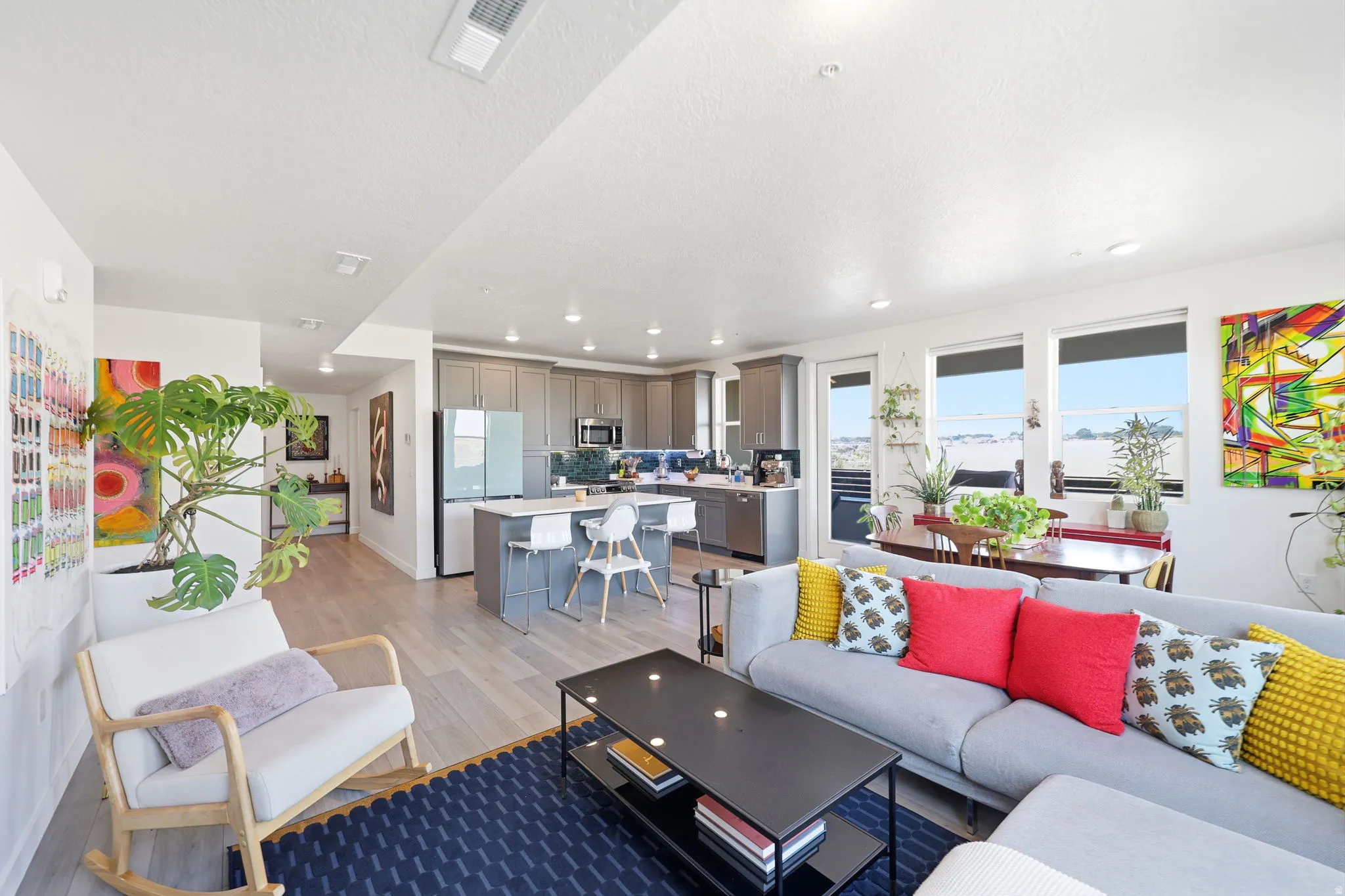 Open-concept living area featuring wood-finish flooring, recessed lighting, and large windows