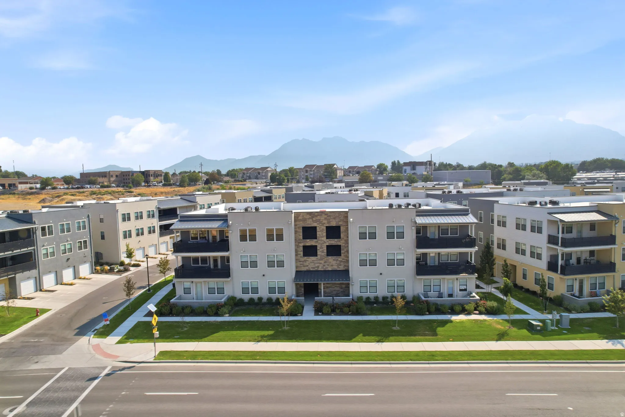 Modern multi-story buildings featuring a mix of siding materials including stone, stucco, and paneling