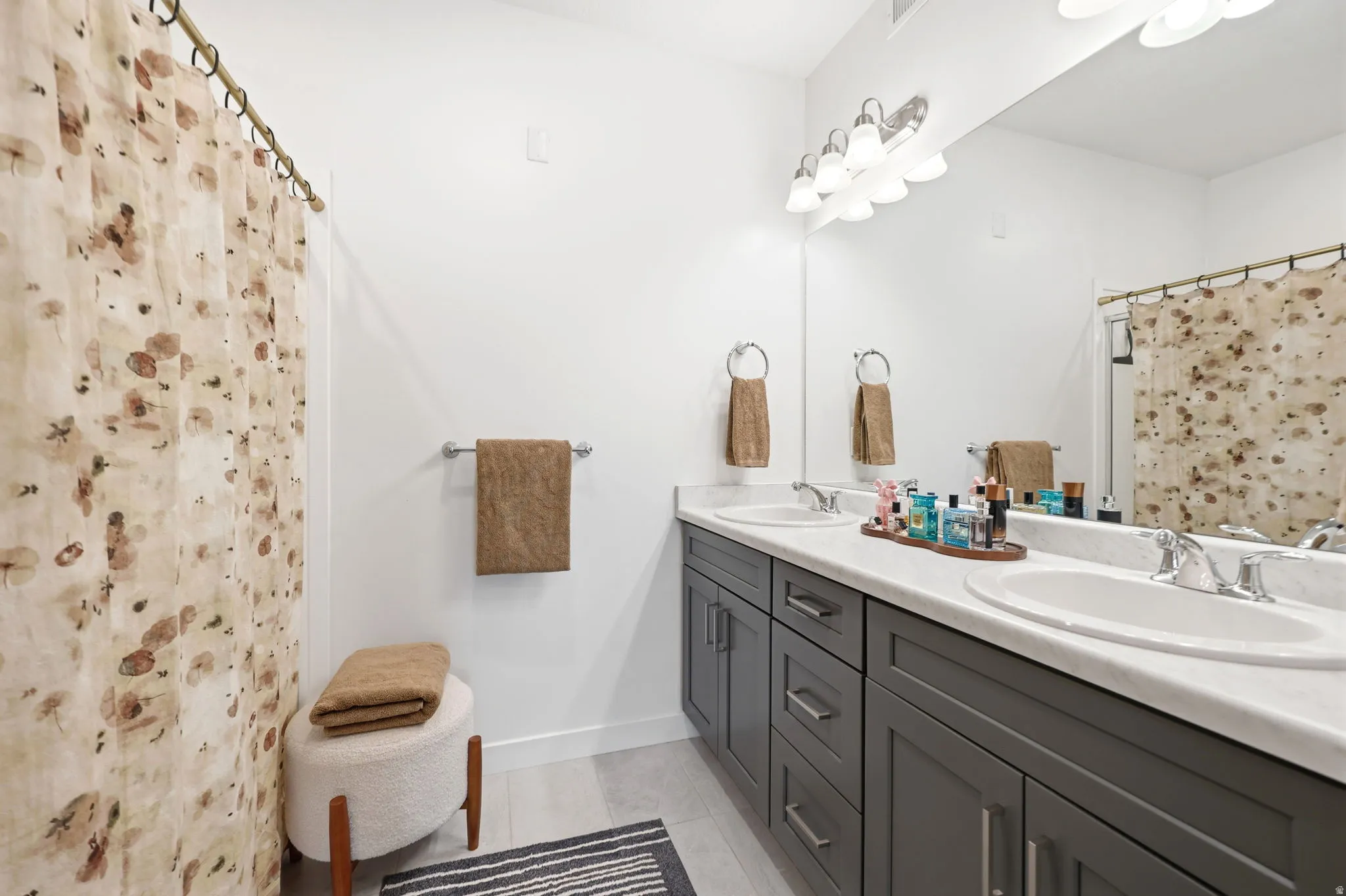 Dual vanity with undermount sinks, gray shaker-style cabinetry, and a full-width mirror