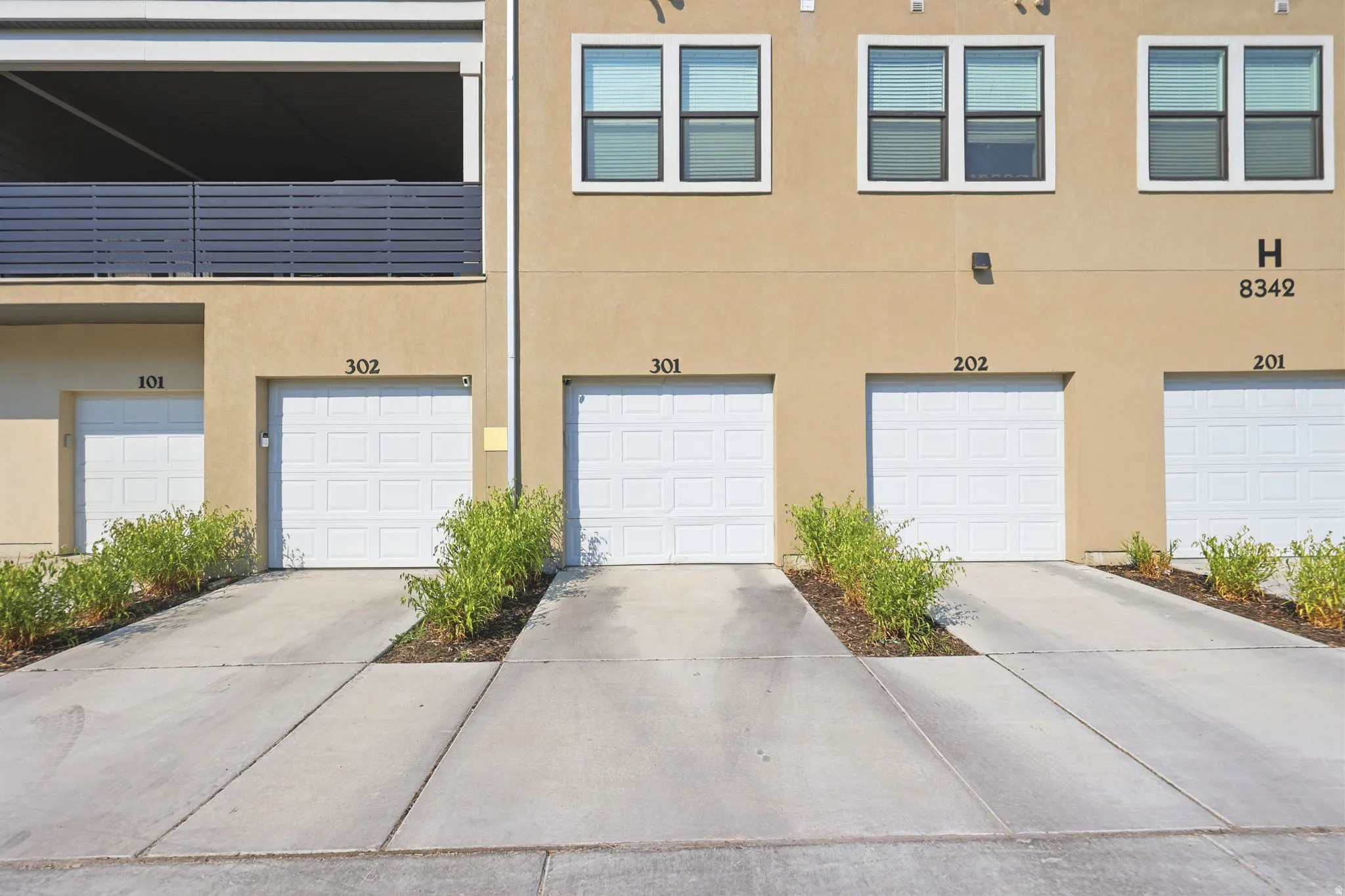 Individual garage bays with concrete driveways