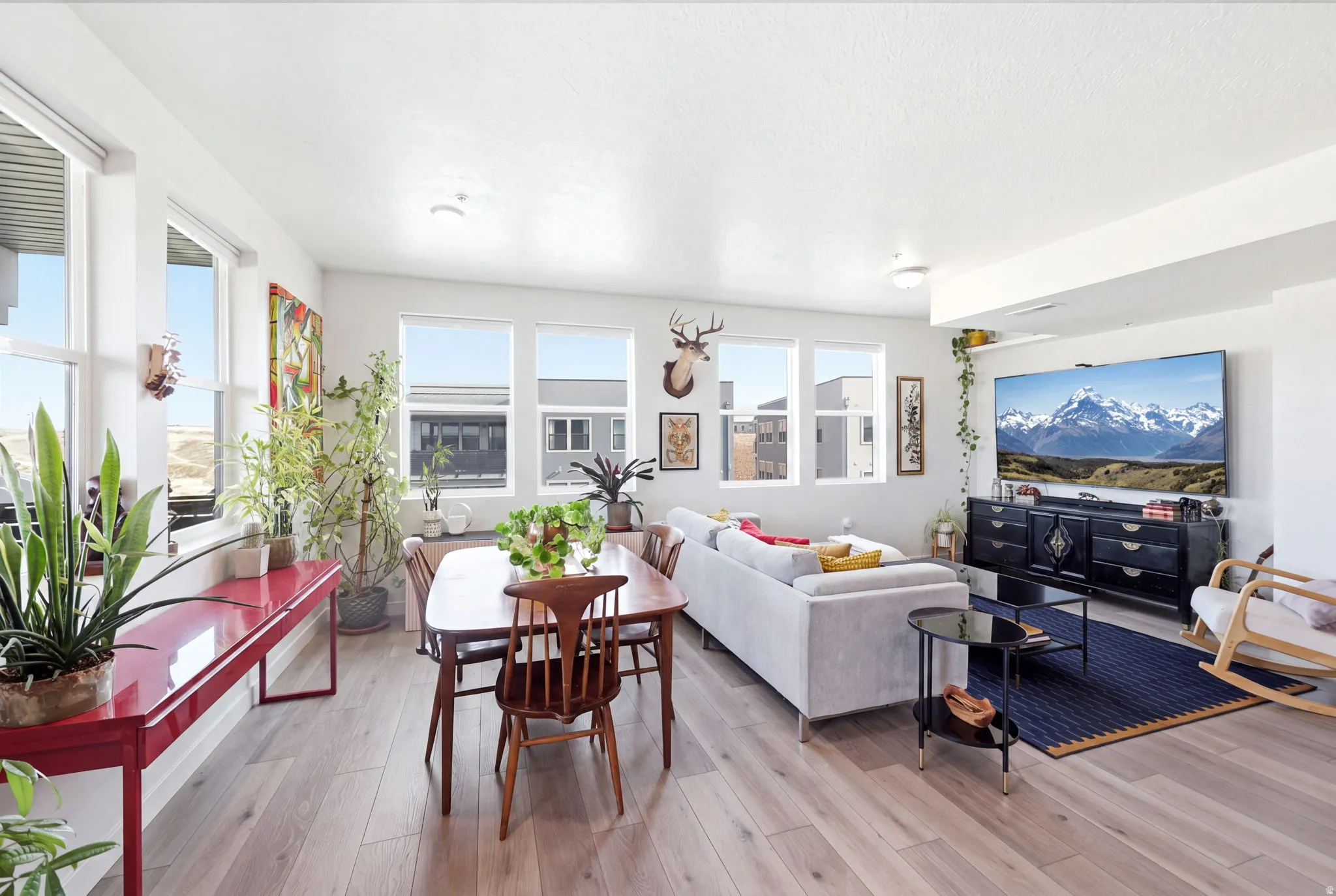 Open-concept living space with light wood-finish flooring, multiple windows, and recessed lighting
