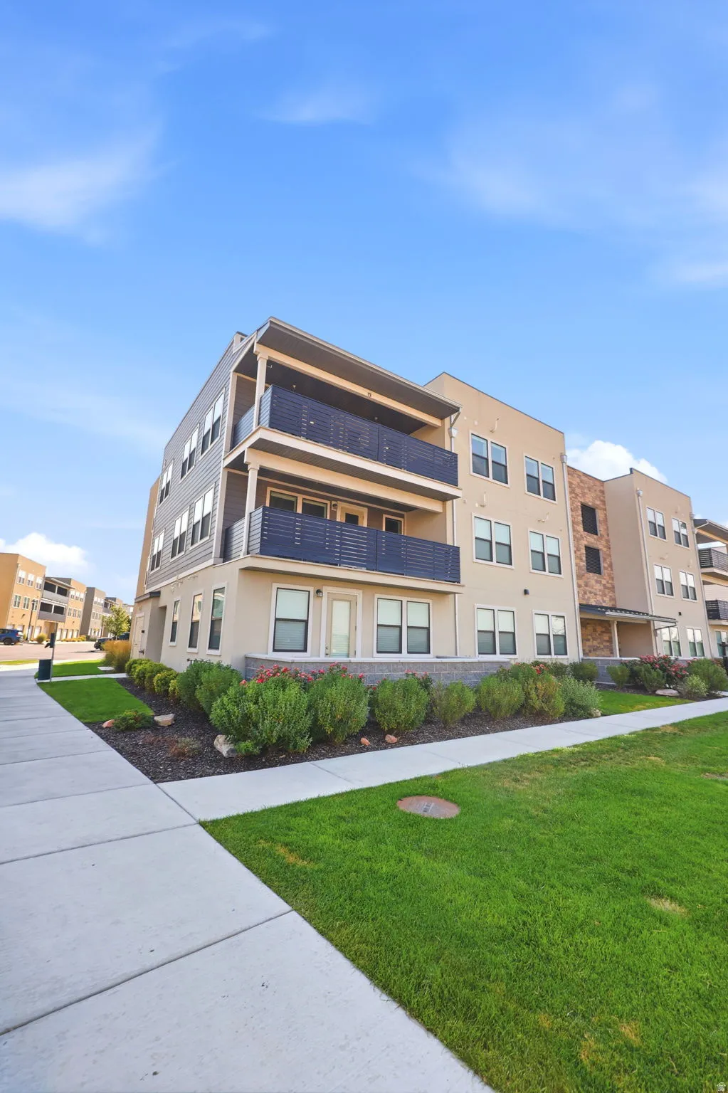 Multi-story residential building with private balconies and ground-level patios