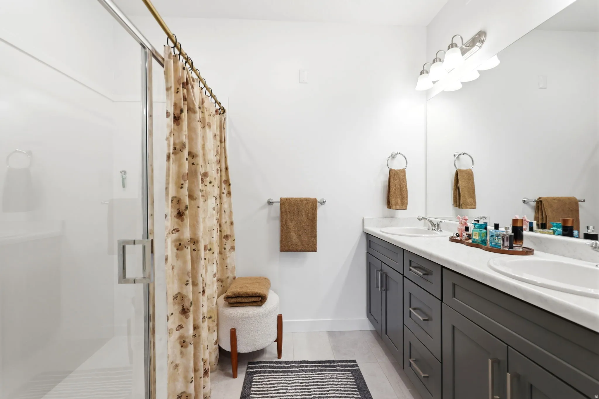 Dual vanity with under-mount sinks, a spacious countertop, and gray shaker-style cabinetry
