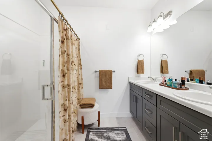 Dual vanity with under-mount sinks, a spacious countertop, and gray shaker-style cabinetry