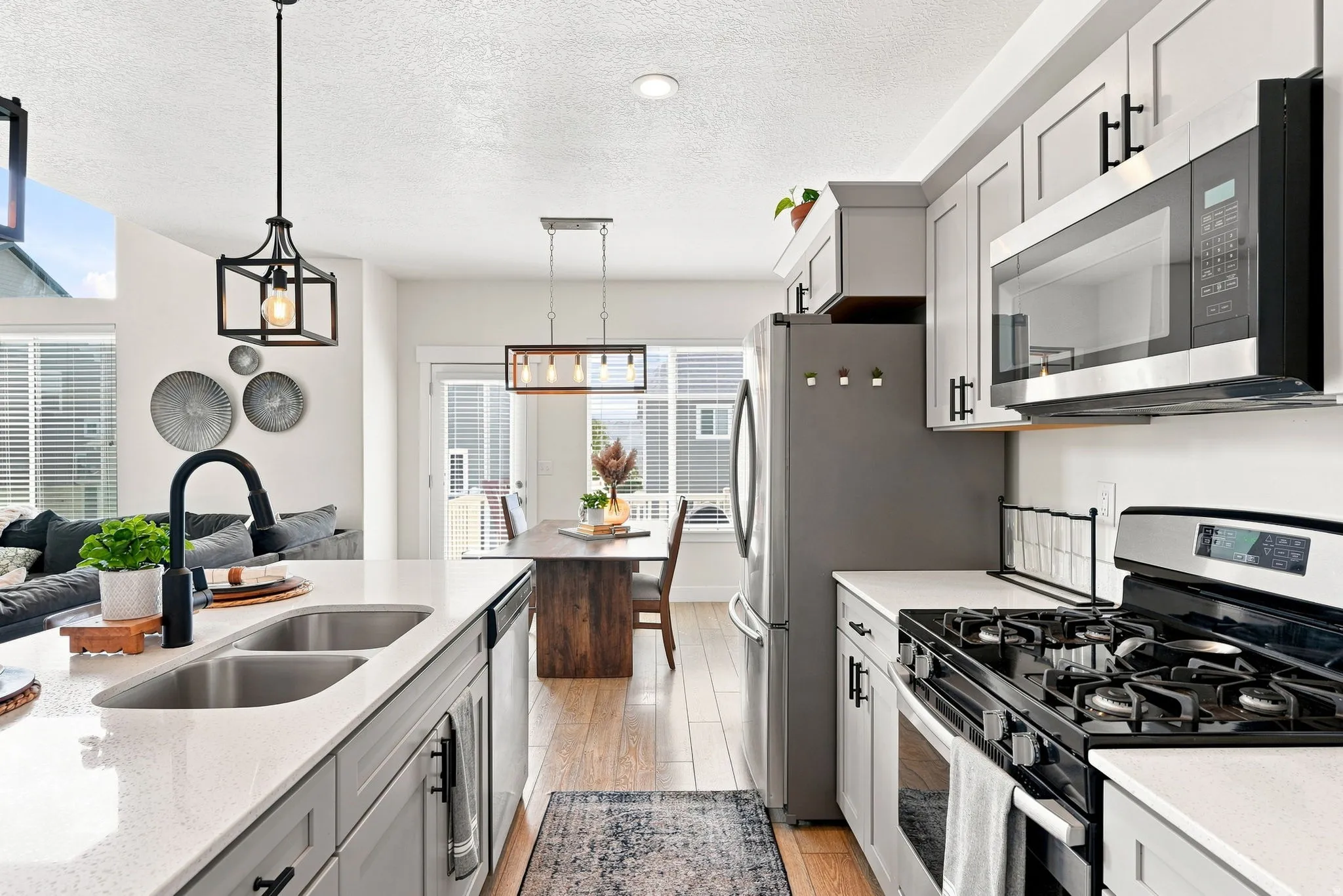 Kitchen featuring light gray cabinetry, stainless steel appliances, white countertops, and wood-finish flooring