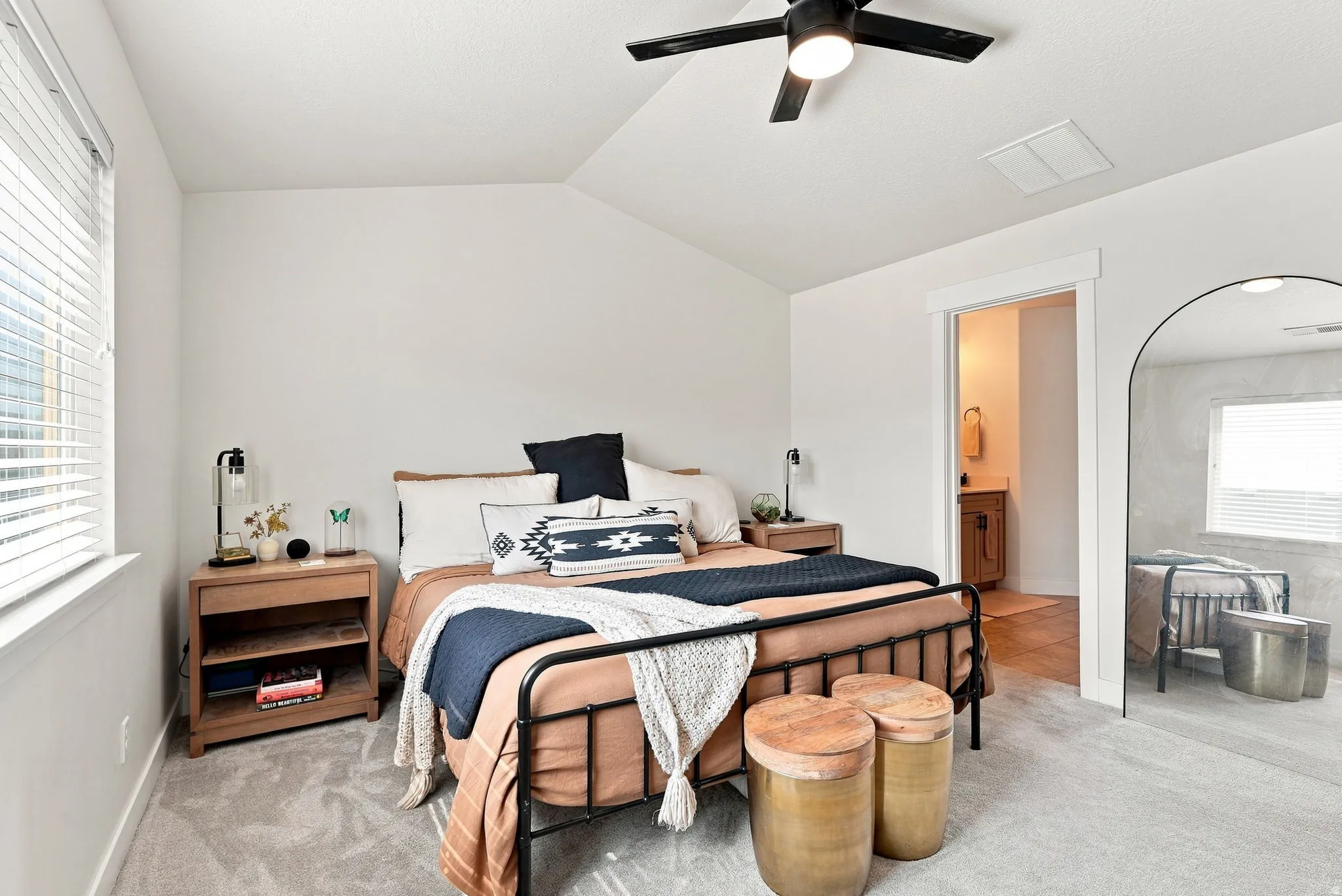 Primary Suite, vaulted ceiling with a black ceiling fan, carpet flooring, a window with blinds, and an entryway to a bathroom