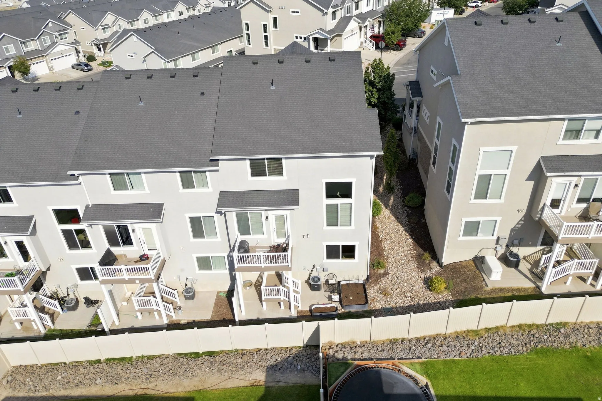 Townhome exteriors featuring multiple balconies, private patios, and an asphalt shingle roof