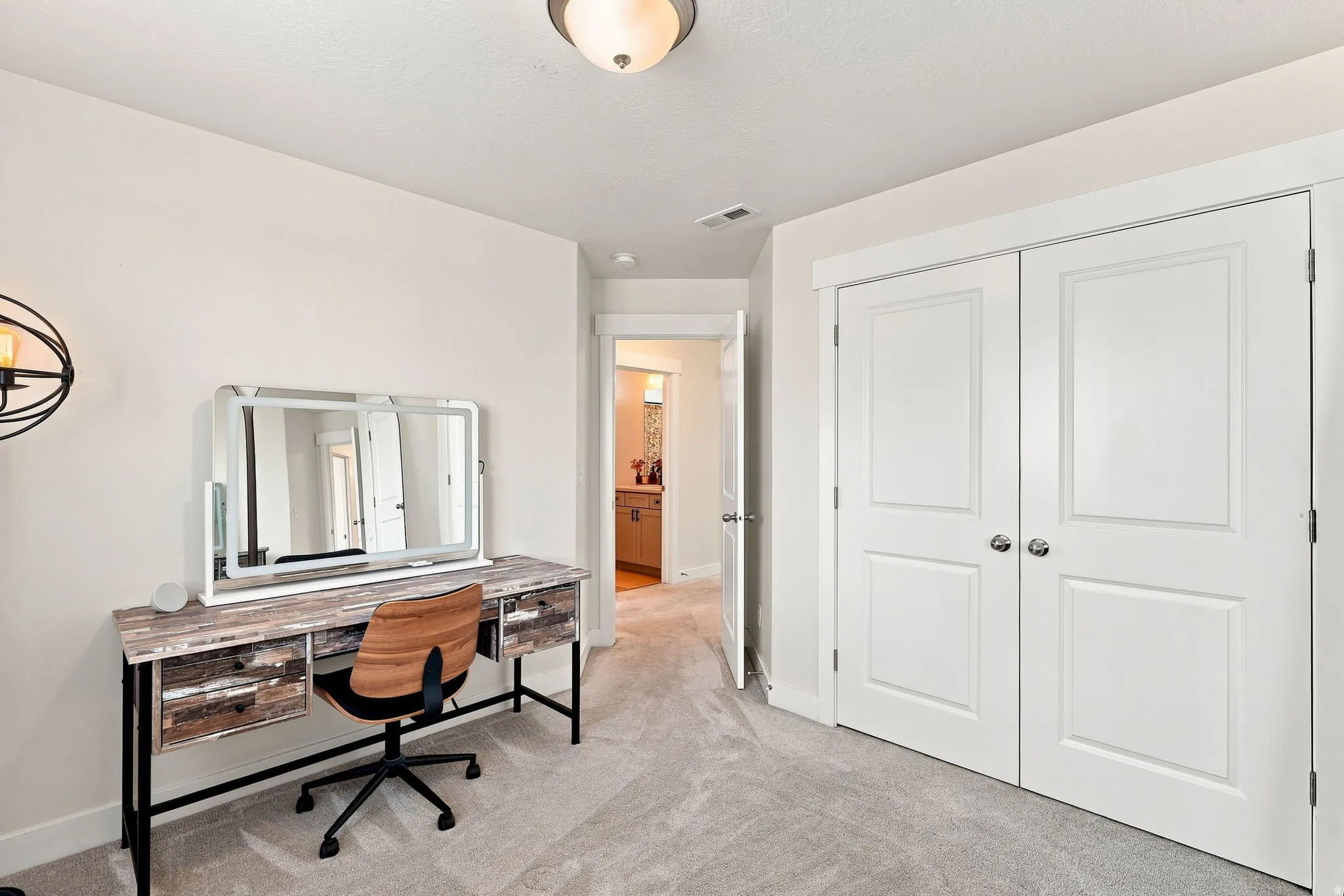 Neutral-toned wall paint, recessed ceiling light, and light gray carpeting