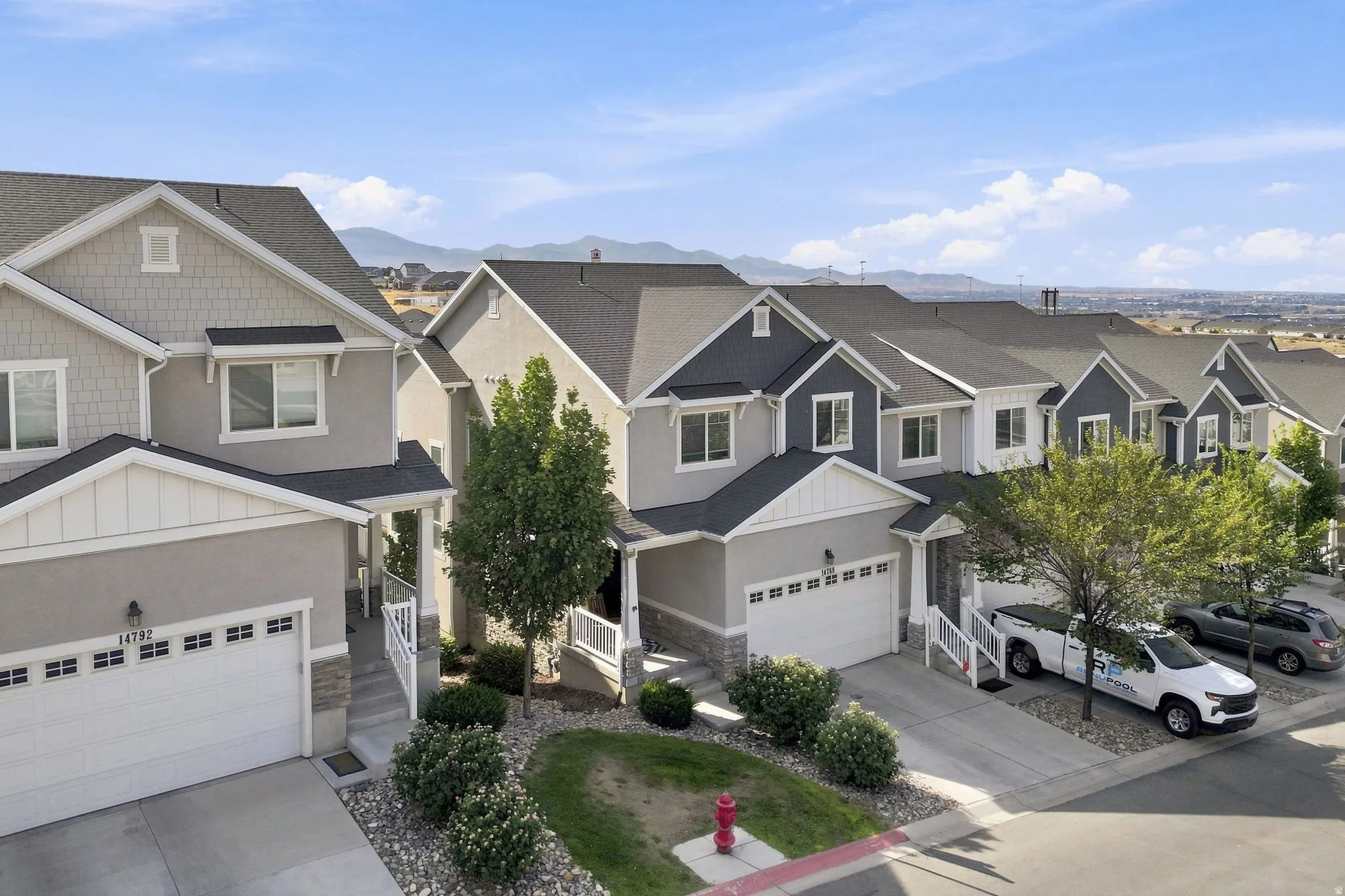 Contemporary residential architecture with shingle and siding accents, attached garage, and mountain scenery