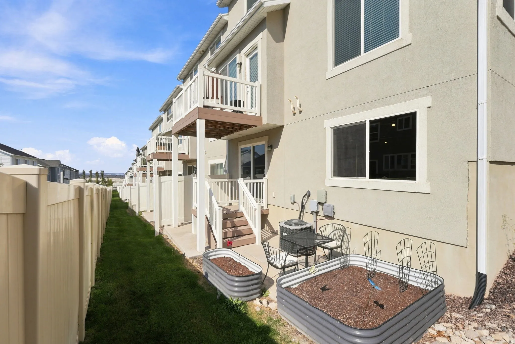 Ground-level patio with two raised garden beds, a concrete pad, and a privacy fence