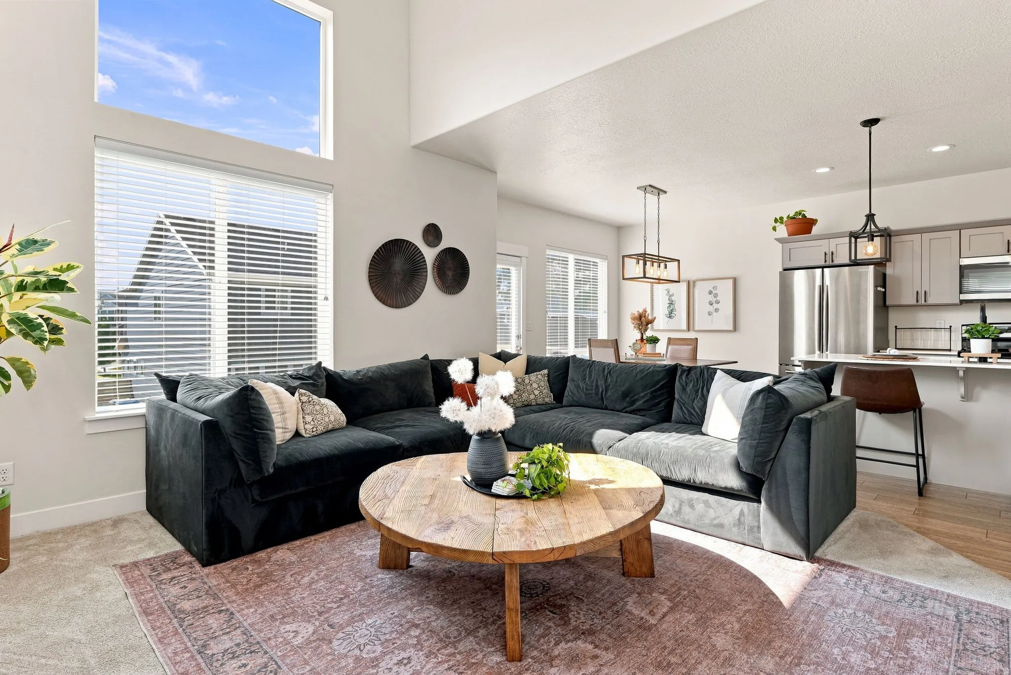 High ceilings, a large accent window, pendant lighting, stainless steel appliances, and wood-finish flooring