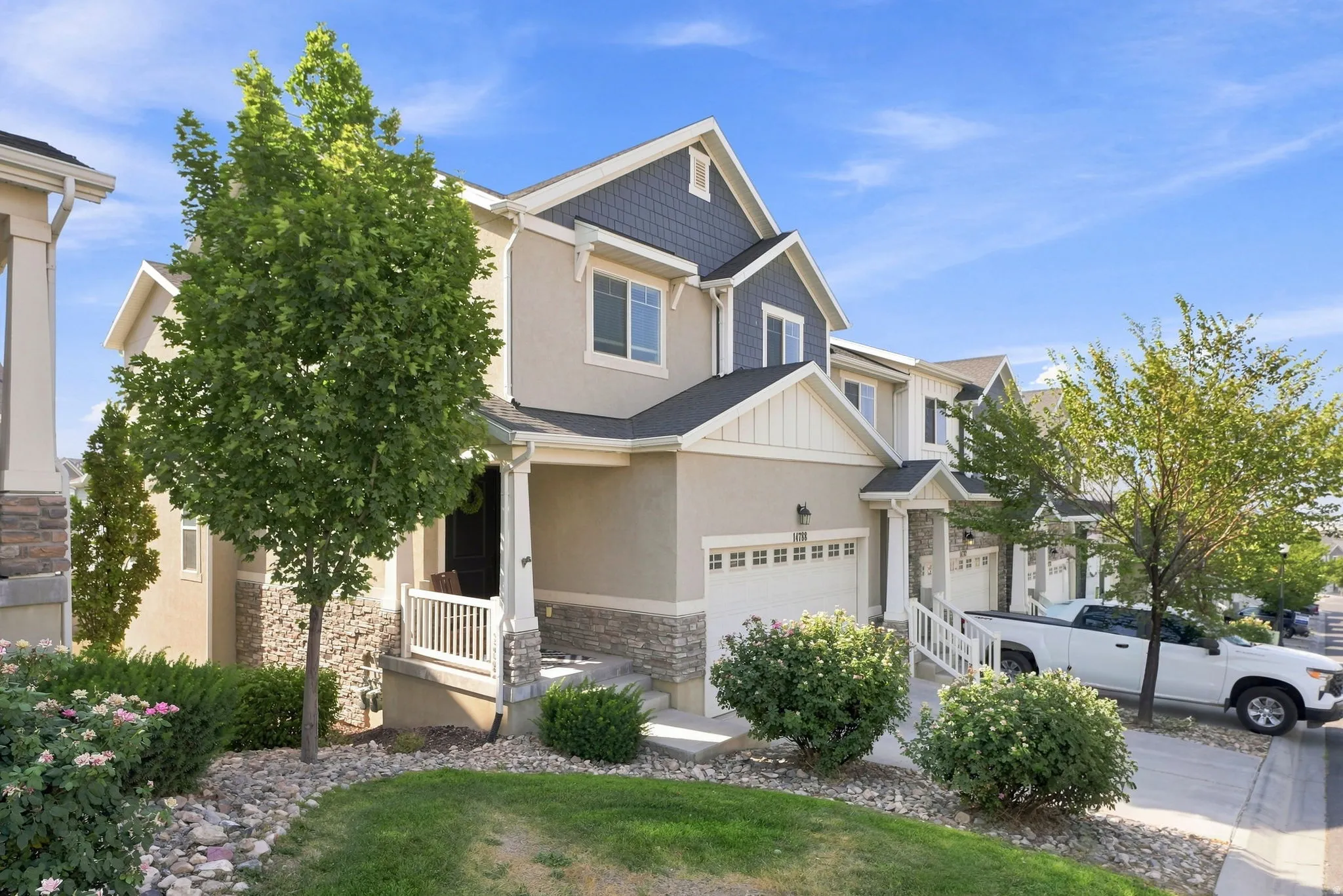 Multi-level property with a two-car garage, stone accents, and a covered entry porch