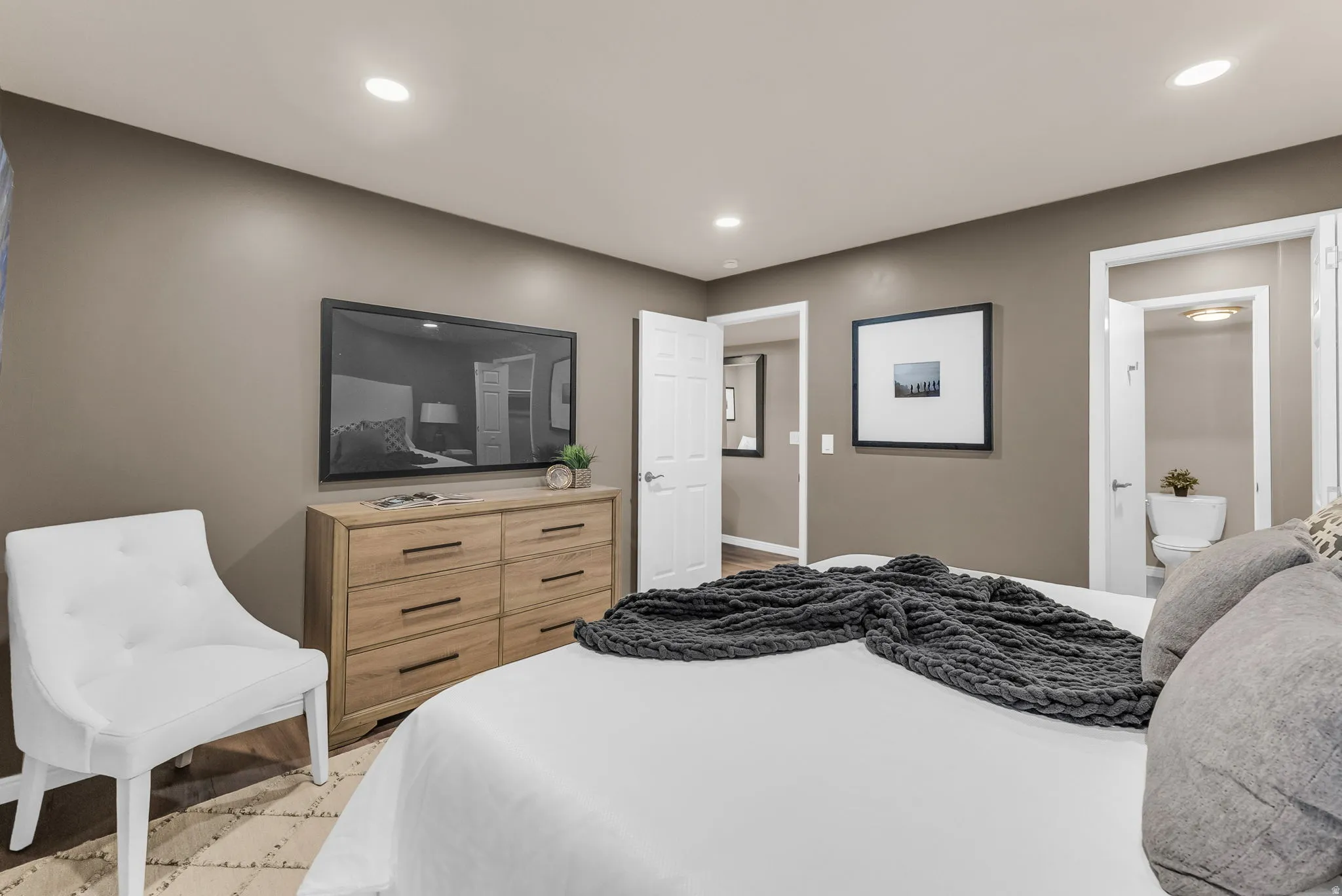 Recessed ceiling lighting, durable flooring, solid core doors, wall-mounted television, and a separate water closet