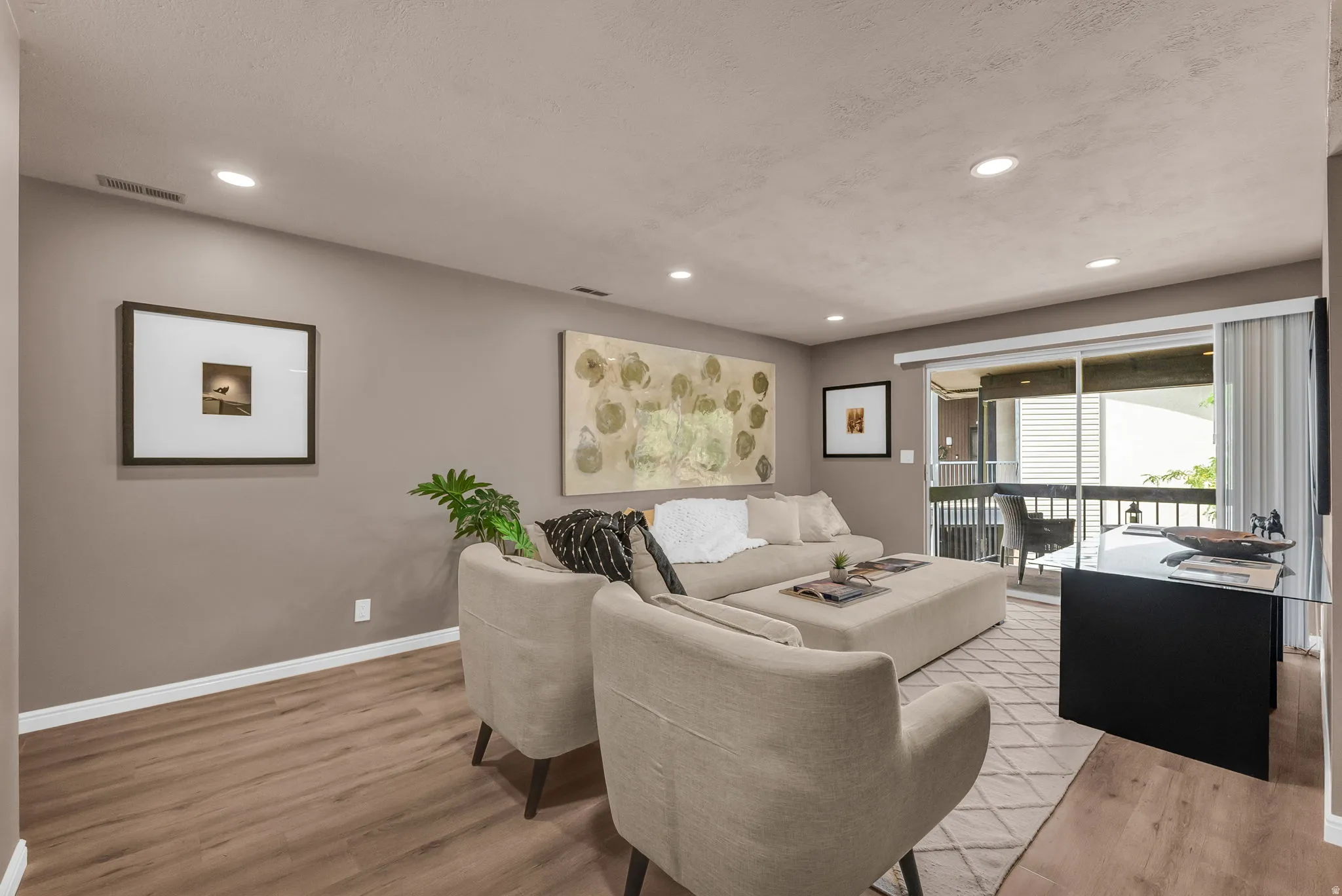 Recessed lighting, wood-finish flooring, sliding glass door, and a private balcony