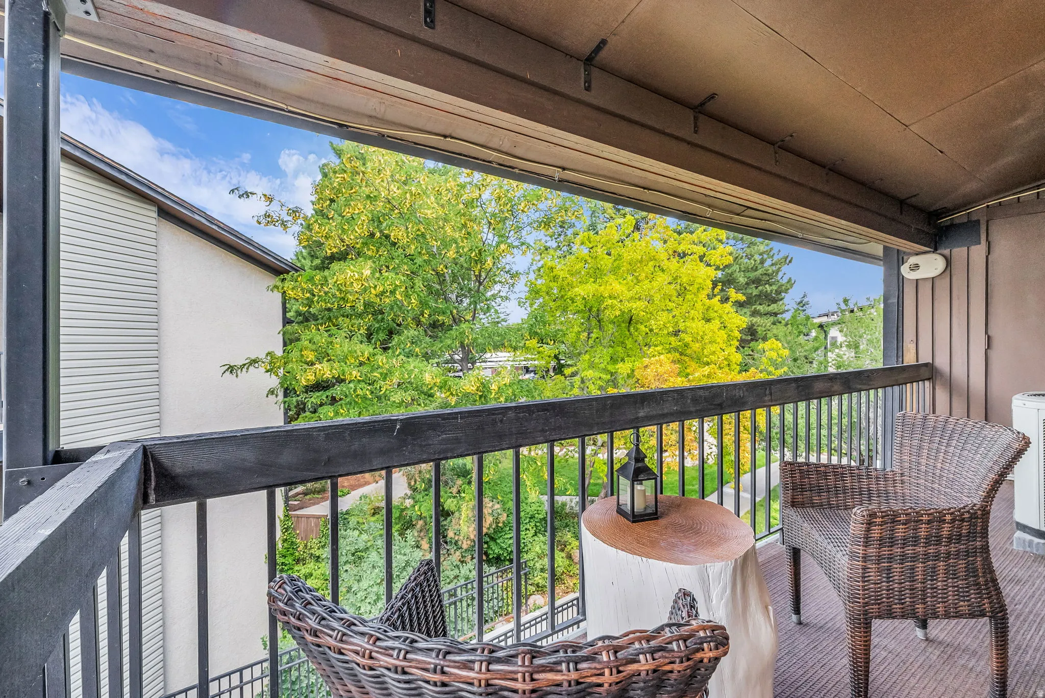 Covered balcony featuring a black metal railing and wood-finish flooring
