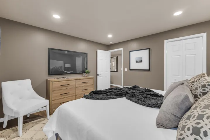 Recessed lighting, wood-finish flooring, and white paneled doors